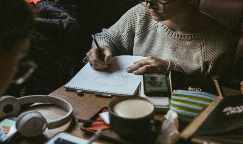 Woman with a notepad and coffee at a table